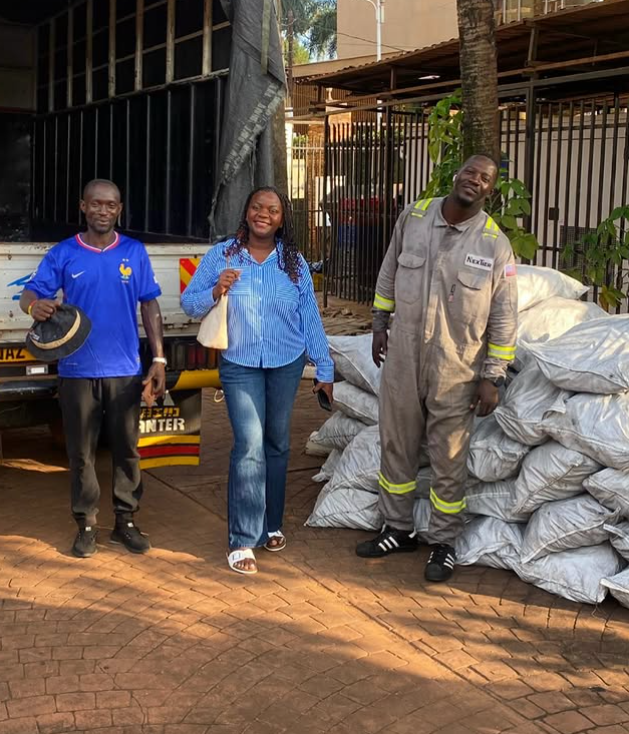Community members beside bags of distributed charcoal
