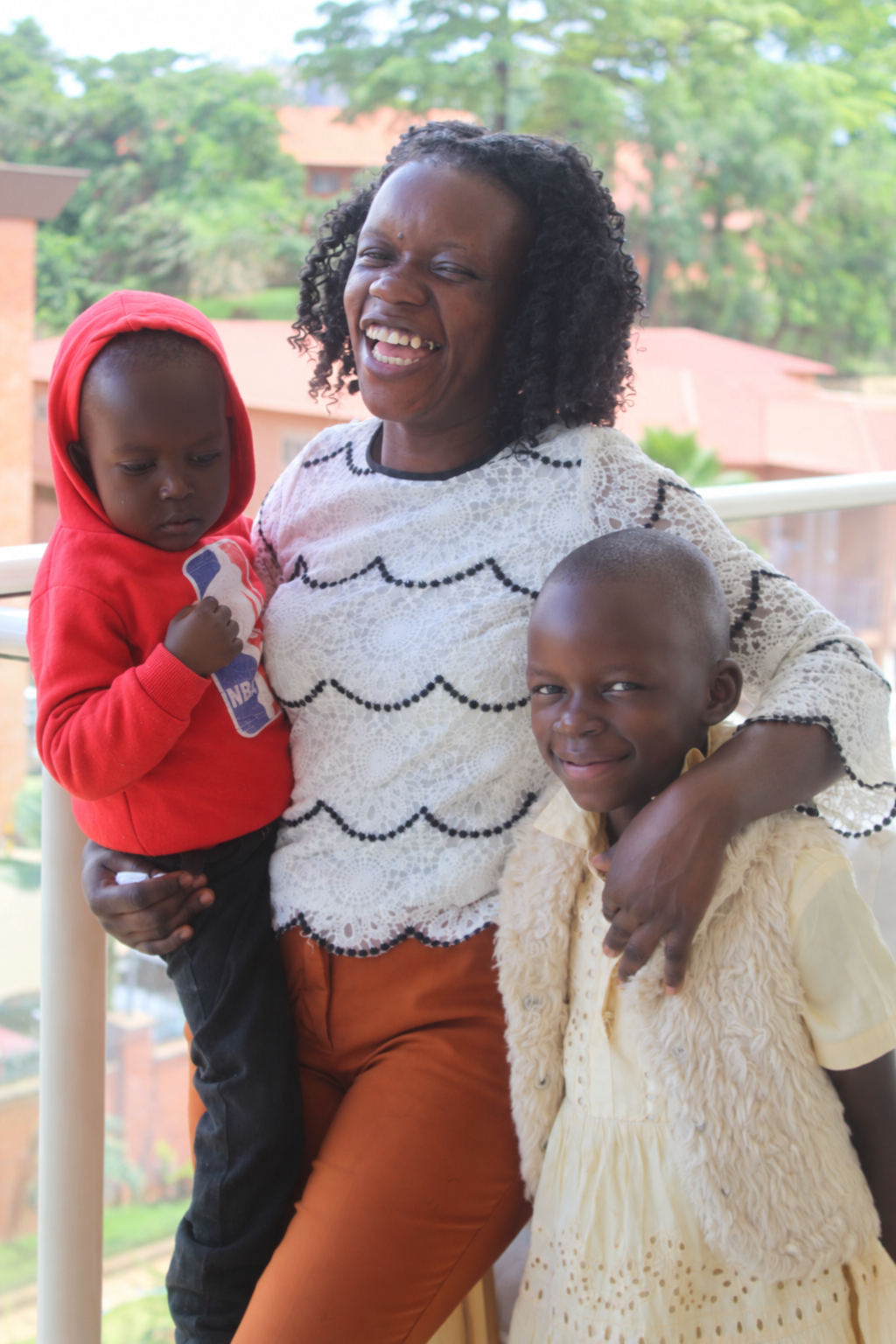 A young mother smiling with two children
