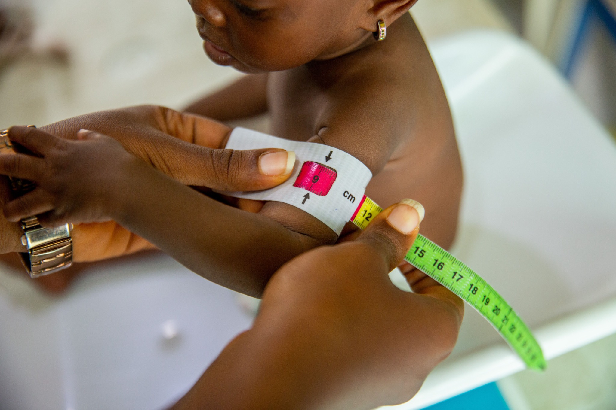 A healthcare worker measuring a child's arm